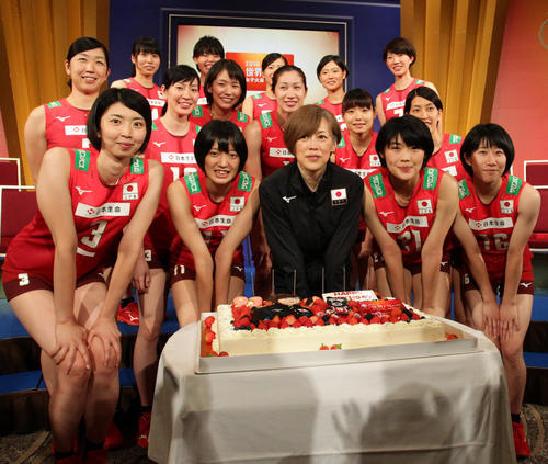 世界バレーの会見で、中田監督へのサプライズの誕生日ケーキに笑顔を見せる女子日本代表の選手たち。後列左から3人目が佐藤さん=2018年9月