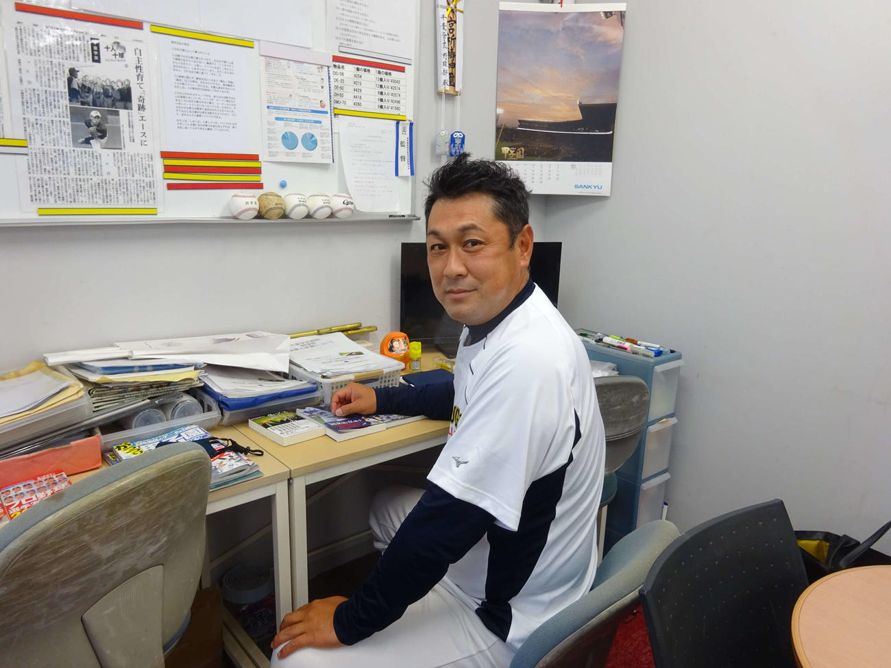 千葉学芸グラウンドにある教官室で選手のデータを調べる千葉学芸・高倉監督