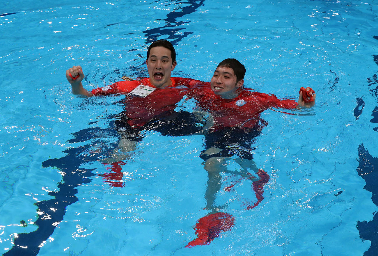 東京五輪・競泳競技の全日程が終了し、プールに飛び込んで記念撮影する瀬戸（左）と萩野＝2021年8月1日