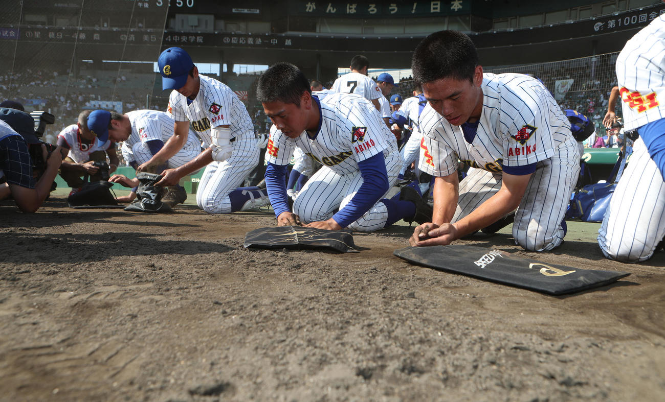 夏の甲子園で済美に敗れ、袋に甲子園の土を入れる中央学院ナイン（18年8月5日）