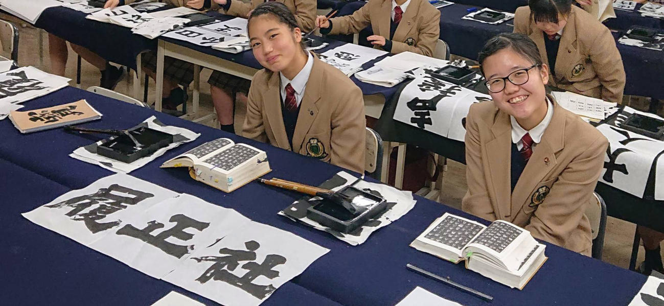センバツに向けて作品を仕上げた履正社担当の石田瞳さん（左）と明石商を担当し今春卒業した大野詩織さん（芦屋書道部提供）
