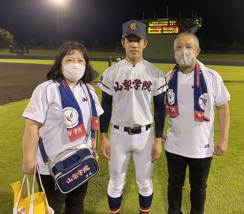 山梨学院対帝京三　試合後に写真に納まる山梨学院・渡辺太介投手（中央）と、左から母・あかねさん、1人おいて父・浩二さん（撮影・湯本勝大）