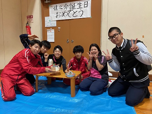 豊中高校能勢分校体育館で沖沢慎之介（左）の誕生日を祝った卓球部。居合わせた部外の生徒（右）も笑顔を見せる