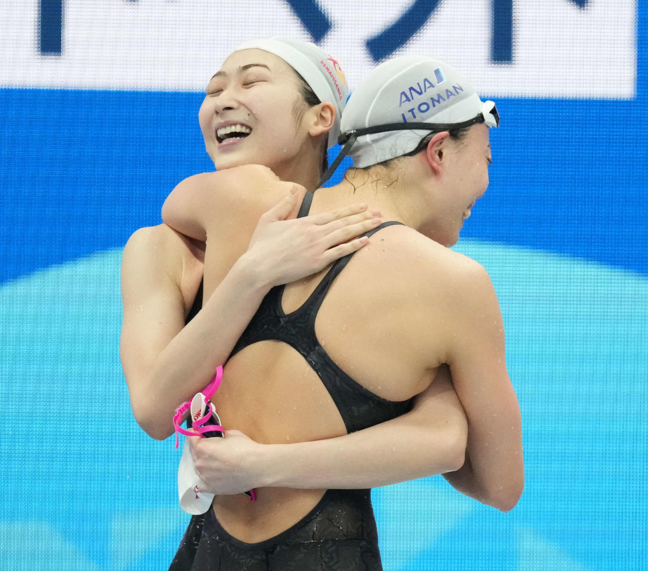 女子100メートル自由形で優勝した池江（左）は4位の大本と抱き合って喜ぶ
