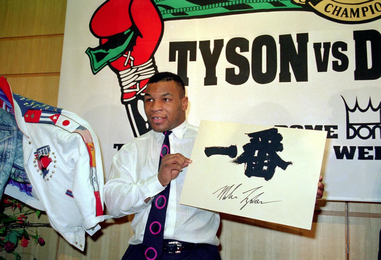 ダグラスとの統一ヘビー級タイトルマッチのため来日し、会見で「一番」と自らのサインが書かれたボード見せるマイク・タイソン（1990年1月16日）