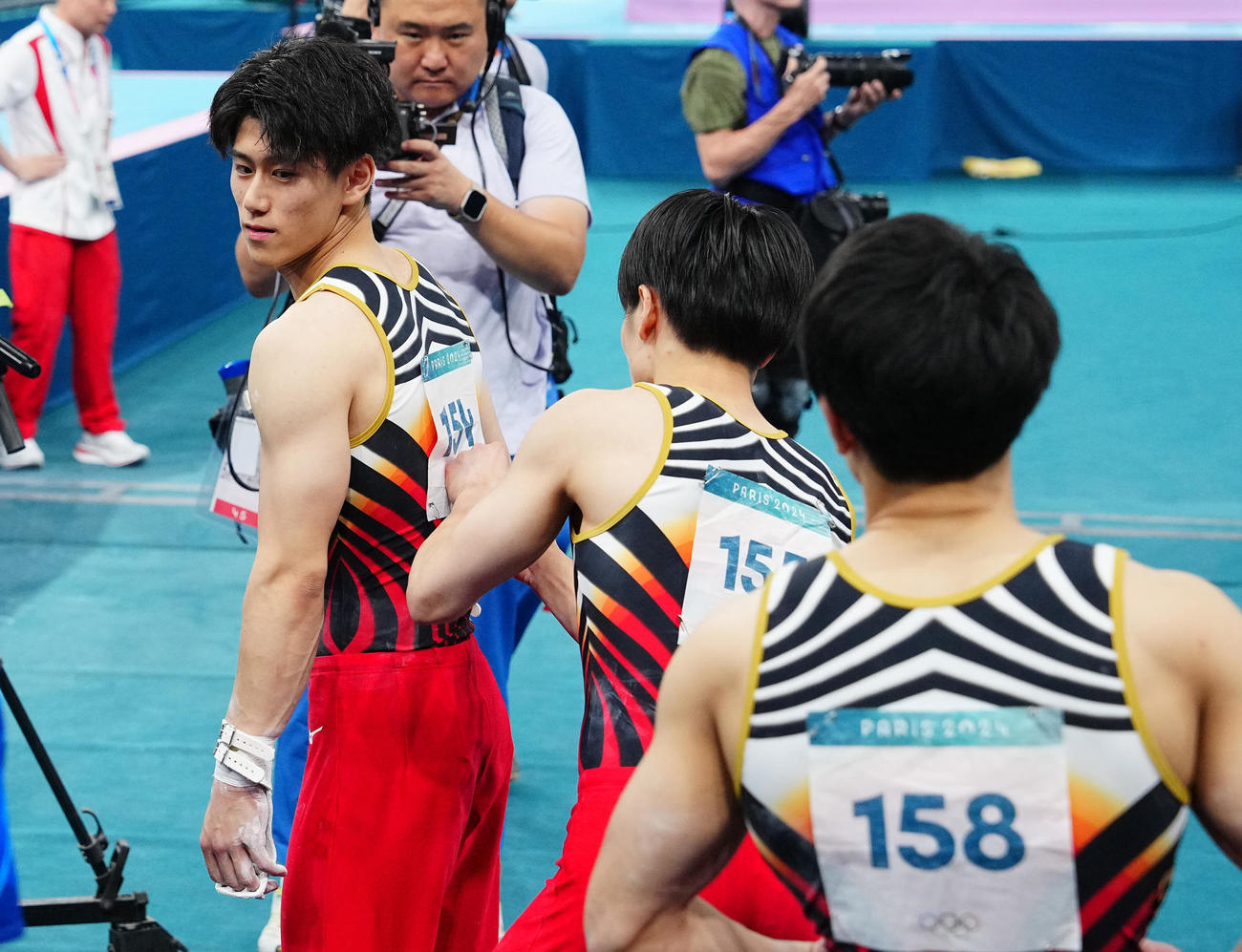 体操男子団体決勝、最終種目の鉄棒の演技を前に仲間たちに背中をたたくよう促す橋本（左）（撮影・垰建太）