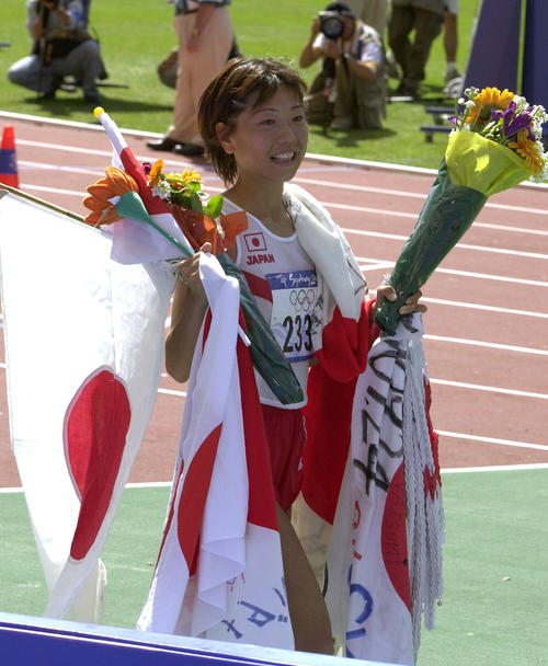 女子マラソン　ウイニングランで、持ち切れないほどの日の丸と花束を手に笑顔を見せる高橋尚子