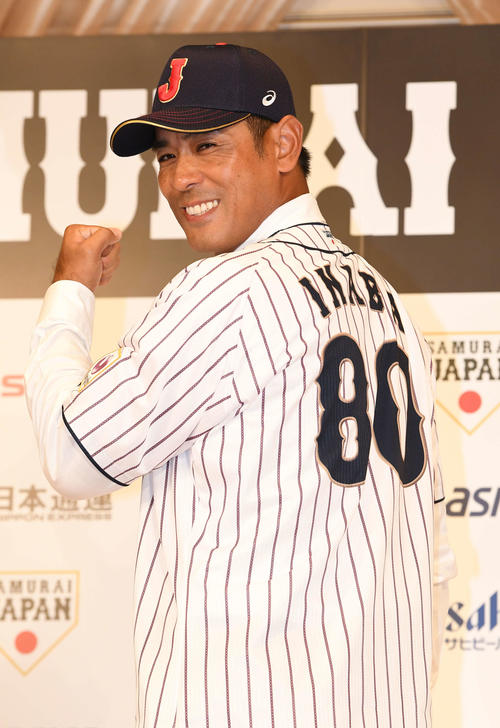 ユニホームに袖を通し笑顔でガッツポーズする侍ジャパン稲葉新監督