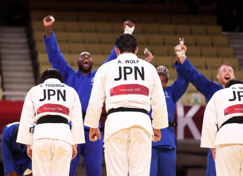 男女団体決勝で敗れて銀メダルの日本チームは一礼する。奥は歓喜するリネールらフランスチーム（撮影・パオロ・ヌッチ）