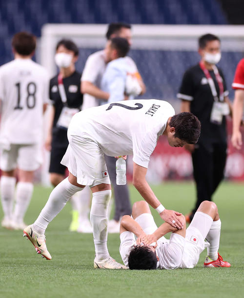 ピッチで涙する久保（右）に声をかける酒井（撮影・河野匠）