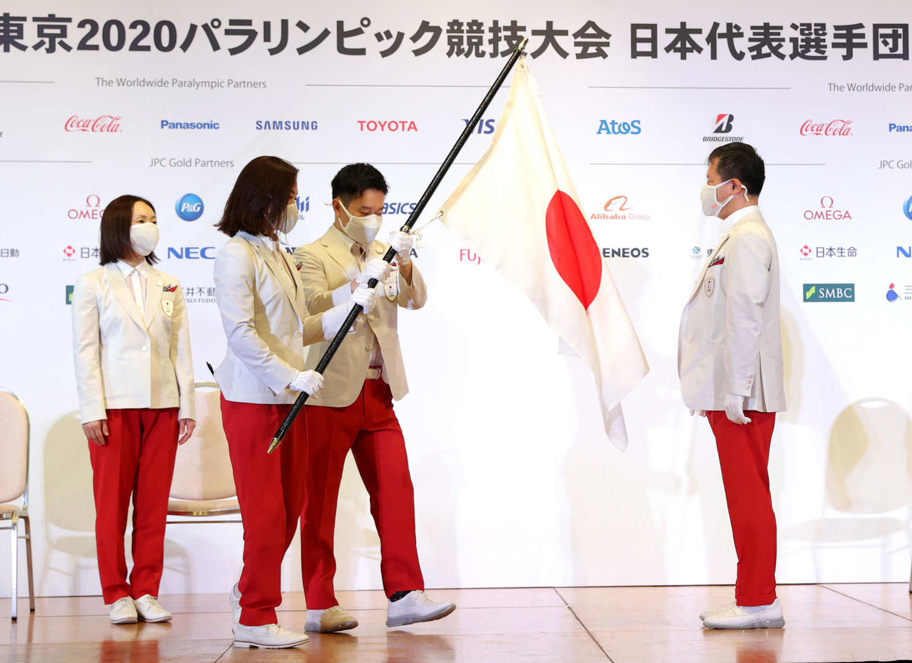 東京パラリンピック団旗返還式で旗手の谷（左から2人目）と岩渕（同3人目）は河合団長に団旗を渡す。左は浦田副主将（代表撮影）