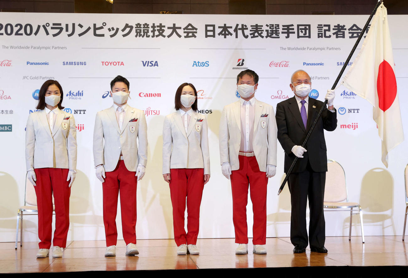 東京パラリンピック日本選手団の河合団長（右から2人目）から団旗を受け取ったJPC鳥原光憲会長。左から旗手を務めた谷と岩渕、浦田副主将（代表撮影）