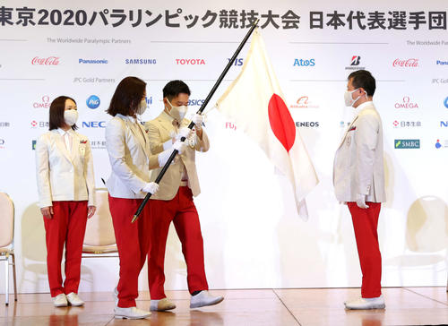 東京パラリンピック団旗返還式で旗手の谷（左から2人目）と岩渕（同3人目）は河合団長に団旗を渡す。左は浦田副主将（代表撮影）