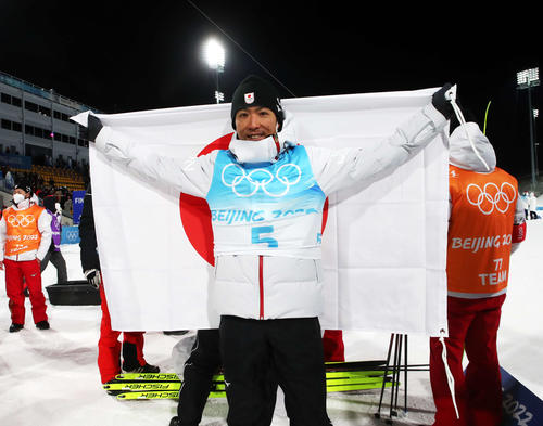ノルディックスキー複合男子個人ラージヒル　銅メダルの渡部暁斗は日の丸を掲げて笑顔（2022年2月15日撮影・パオロ　ヌッチ）