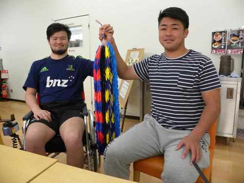 千羽鶴を手に笑顔を見せる京都産業大の中川将弥（左）と同志社大の野中翔平