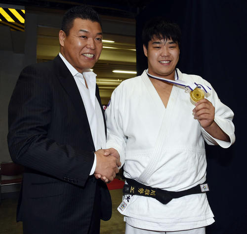 男子１００キロ超級決勝を制した小川雄勢（右）は父直也氏（左）と笑顔で握手を交わす（撮影・今浪浩三）