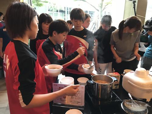 汁物をよそう女子シングルス山口茜（味の素（株）「ビクトリープロジェクト」提供）