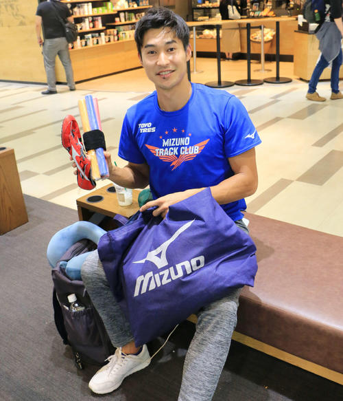 プレゼントするバトンやスパイクを手にする飯塚翔太（撮影・上田悠太）