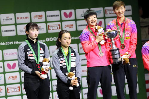 優勝した中国ペアが優勝トロフィーを持って喜ぶ中、銀メダルにも笑顔がない、左から早田ひな、伊藤美誠（2019年4月28日撮影）