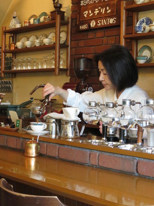 マンデリンをカップに入れる女性店主（撮影・峯岸佑樹）