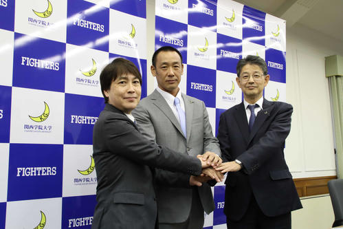 関学大アメフト部の新監督に就任する大村氏と手を合わせる、池埜部長（左）と小野ディレクター（2020年1月22日撮影）