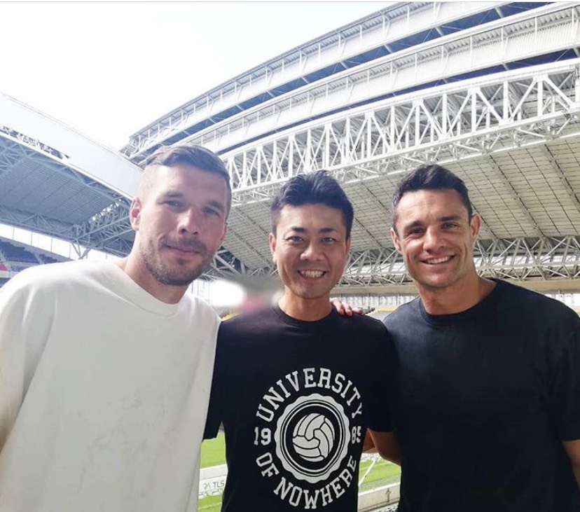 19年にJ1神戸ポドルスキ（左）、神戸製鋼カーター（右）と写真に納まる文元明宏氏（文元氏提供）