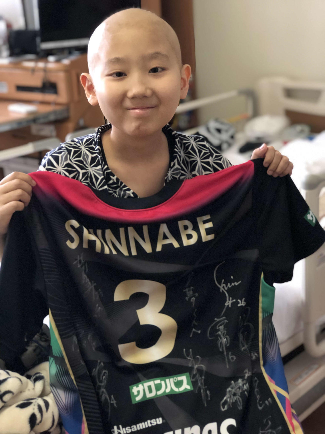 ファン感謝祭で新鍋ら久光の選手からもらったサインユニホームを手にする松本君