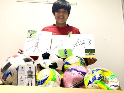 被災地へ贈るサッカーボールと選手から寄せられたサイン色紙を持つ千葉のGK船田（提供写真）