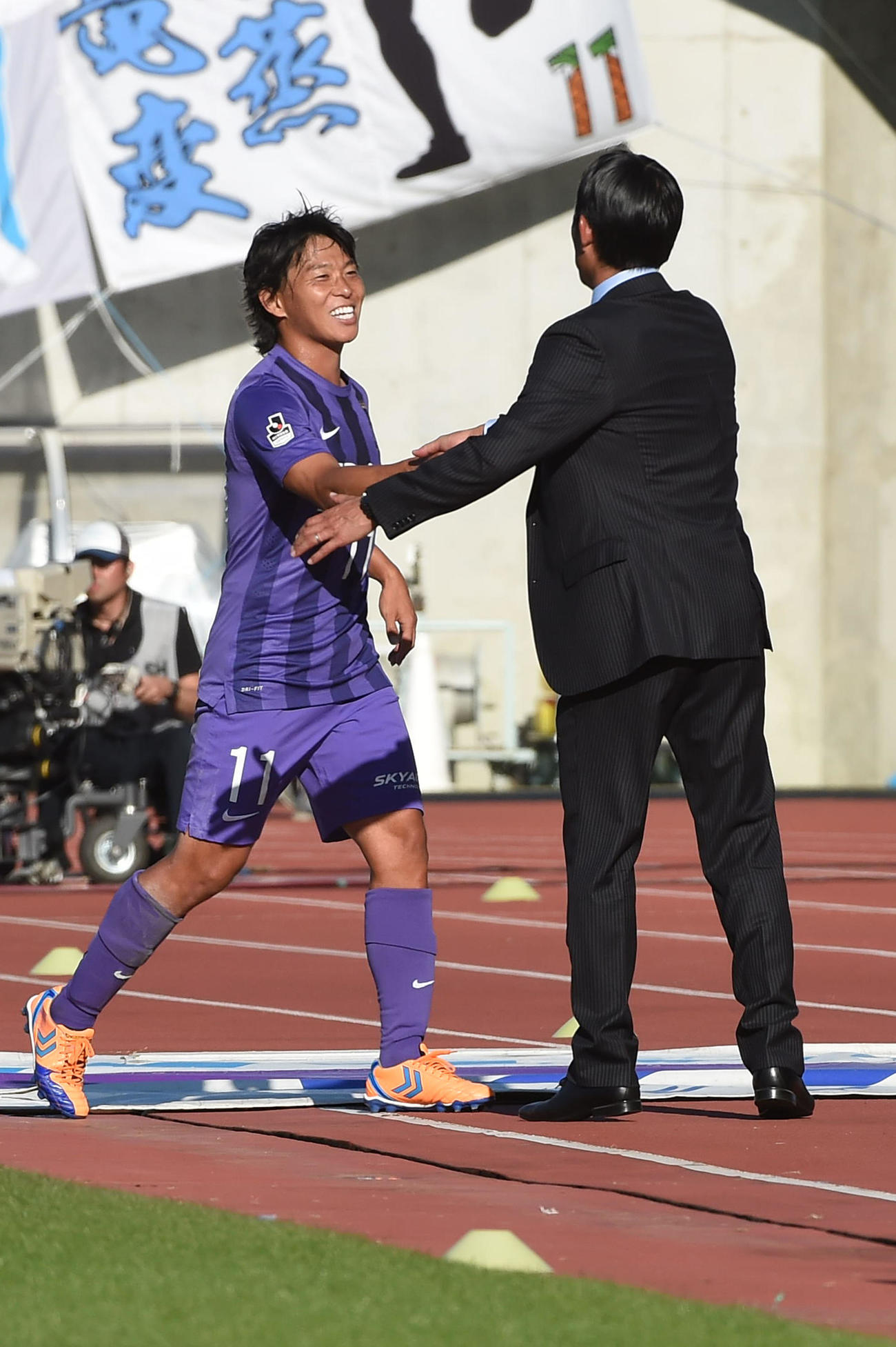 広島森保一監督と笑顔で握手する広島MF佐藤寿人（2015年10月17日撮影）