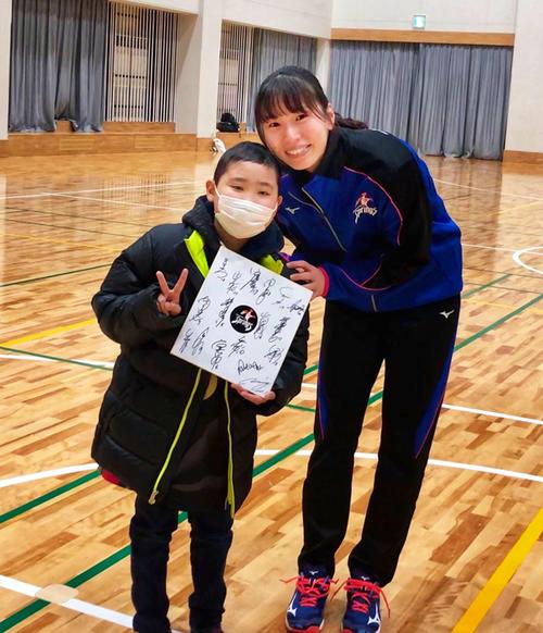 19年12月に開かれた福岡県久留米アリーナでの試合後、新鍋さんと写真を撮る歩夢君（左）