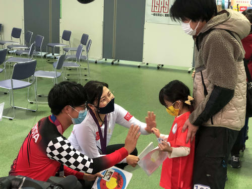 アーチェリー競技体験会に参加した子どもに記念品を送る武藤（左）と早川（左から2人目）（撮影・平山連）
