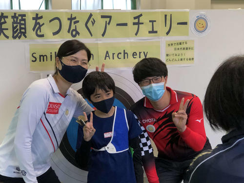 アーチェリー競技の体験会に参加した子どもと記念写真を撮る早川（左）と武藤（撮影・平山連）
