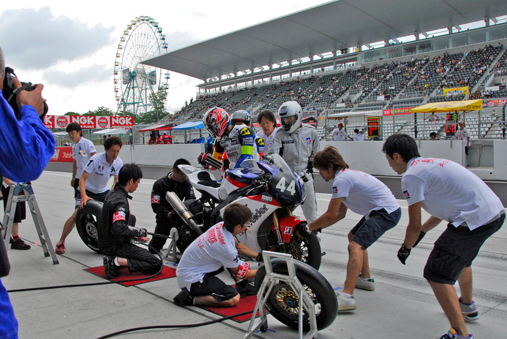 09年の鈴鹿8耐で、ピットインしたマシンのタイヤ交換を行う「DDBOYS」のピットクルーたち。前後輪を外そうとしているところ（撮影・大津賢一）
