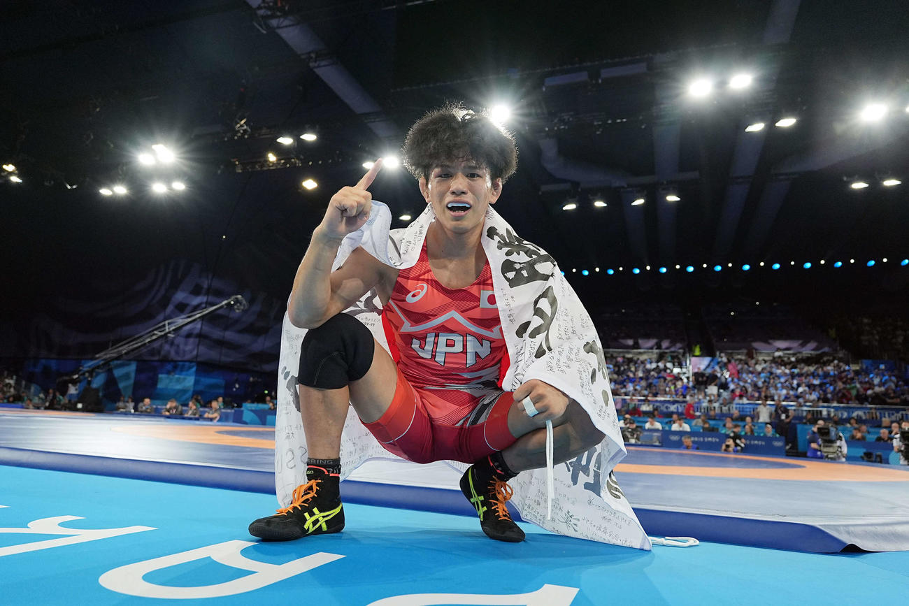 男子フリースタイル65キロ級決勝で金メダルの清岡は日の丸を羽織ってポーズ（2024年8月11日撮影・パオロ　ヌッチ）