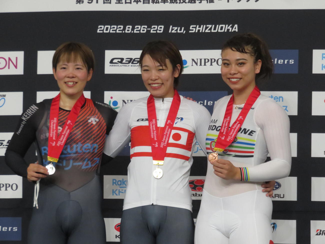 女子スプリントで初優勝した佐藤水菜（中央）。左は2位の梅川、右は3位の太田
