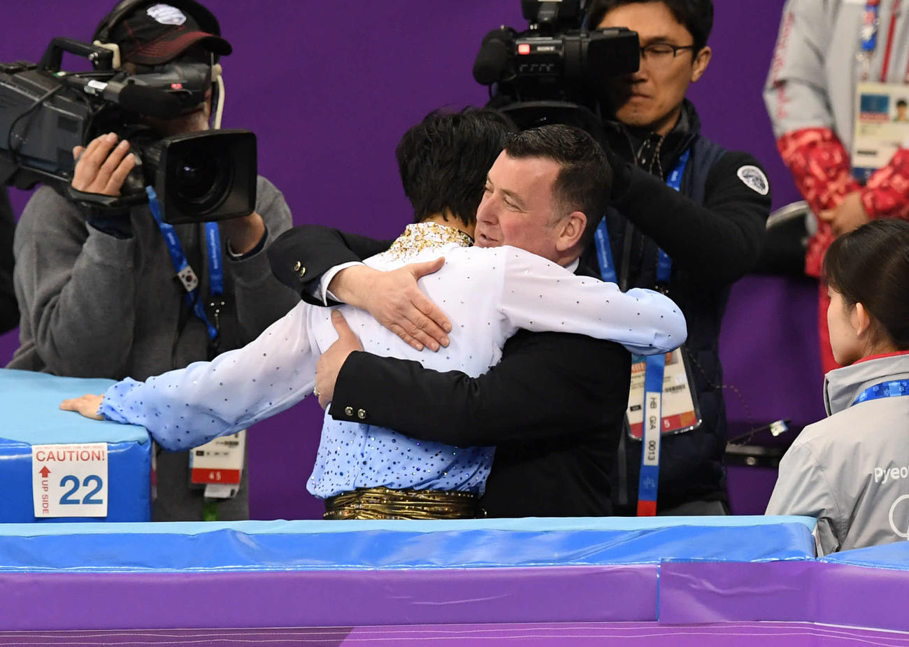 ブライアン・オーサー・コーチと抱き合う羽生結弦（中央左）（2018年2月16日撮影）