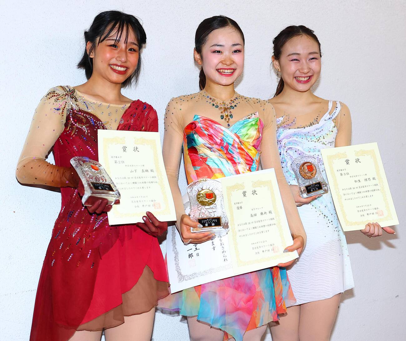 シニア初戦で優勝し表彰台で笑顔をみせる島田麻央（中央）。左は2位の山下真瑚、右は3位の松生理乃（撮影・野上伸悟）