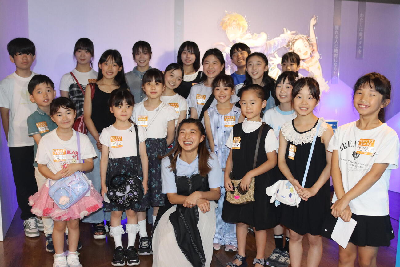 漫画「メダリスト」の展示会に出席した坂本花織さん（前列中央）は子どもたちと記念撮影する（C）つるまいかだ／講談社
