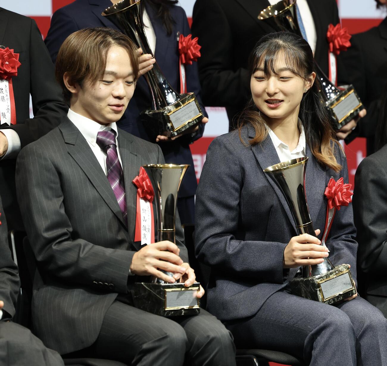 トロフィーを手に言葉を交わす鍵山優真（左）と坂本花織さん（撮影・河田真司）