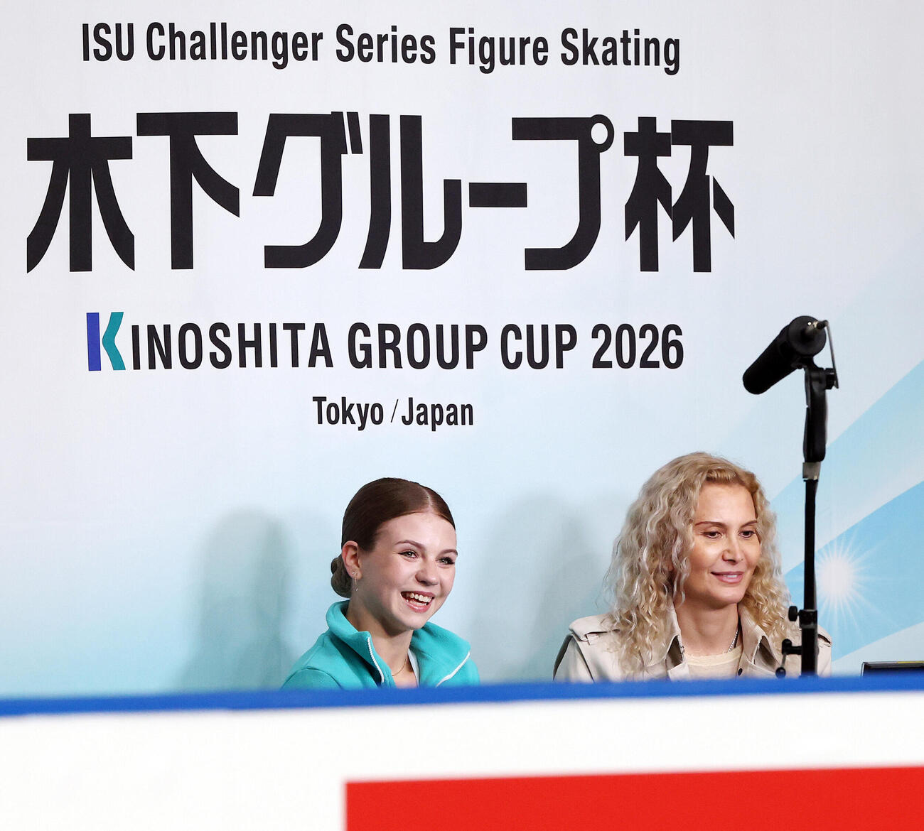 女子SPを終えキス・アンド・クライでコーチのエテリ・トゥトベリーゼ氏（右）と笑顔を見せるアレクサンドラ・イグナトワ（撮影・宮地輝）