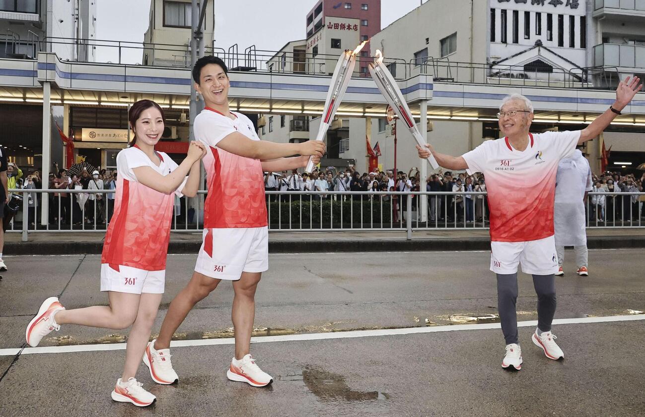 19日に開幕する愛知・名古屋アジア大会の聖火リレーで、ランナーを務めたミラノ・コルティナ冬季五輪金メダルの三浦璃来さん（左）と木原龍一さん（中央）＝16日午後、名古屋市瑞穂区（代表撮影）