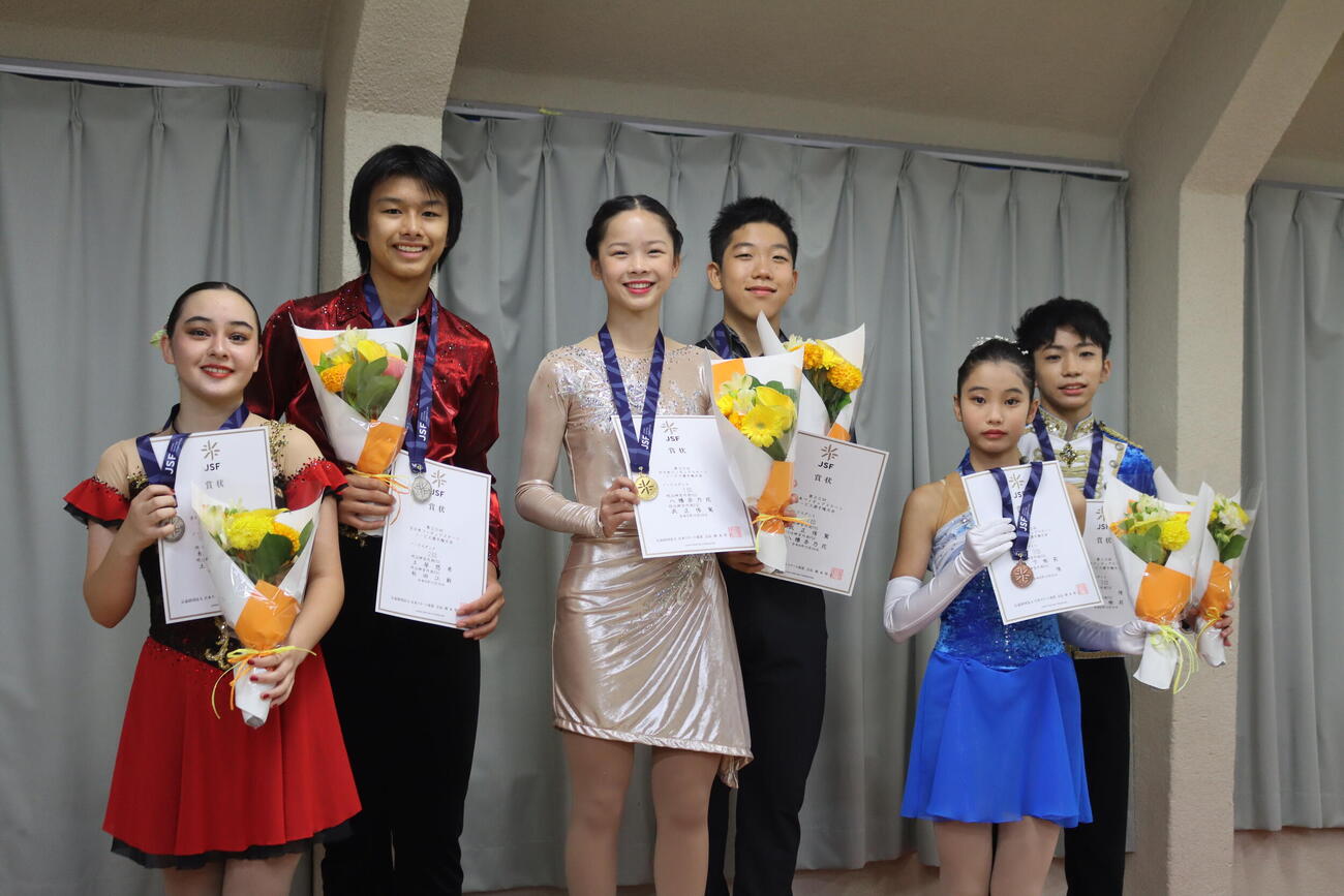 全日本ノービス選手権アイスダンスで優勝した八幡奈乃花、武正侑駕組（中央）。左は2位の秋田江鈴、土屋悠希組、右は3位の藪下桃莉、原侑組