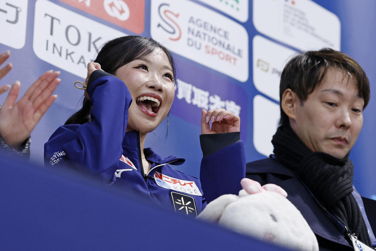 女子フリーの得点を確認し笑顔の中井亜美。右は中庭健介コーチ（共同）
