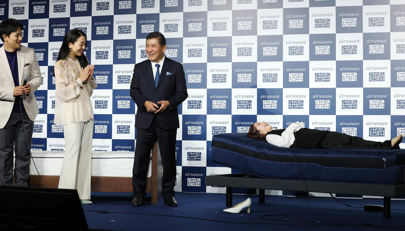 エアウィーヴベッドマットレスを体験する三浦璃来さん（右）を笑顔で見守る、左から木原龍一さん、浅田真央さん、高岡本州代表取締役会長兼社長（撮影・宮地輝）