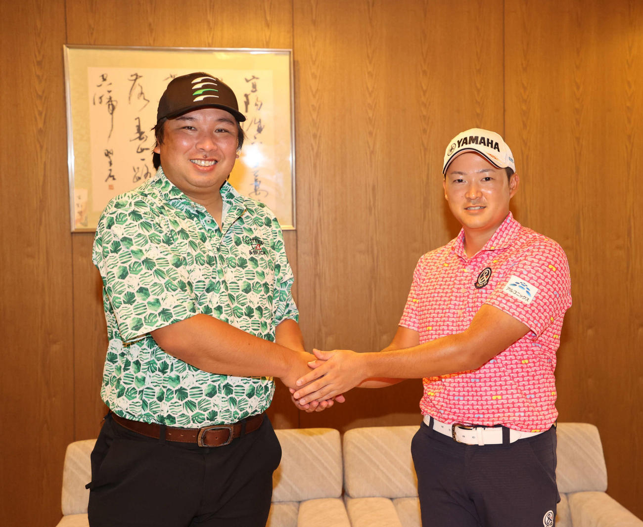 レッスンを終え、がっちり握手する今平周吾（右）と里崎智也