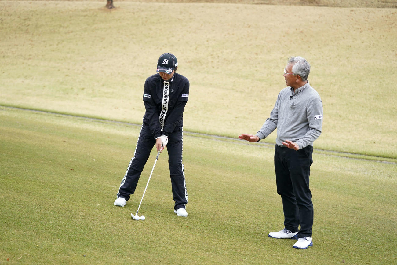 左足下がりで構える大里プロ（左）と新井真一プロ