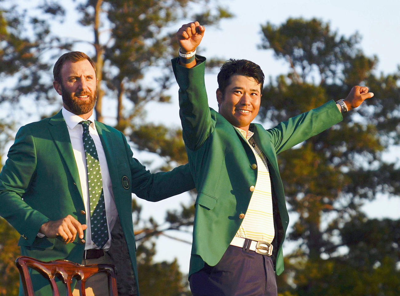 米ゴルフのマスターズ・トーナメントで日本男子初のメジャー制覇を果たし、グリーンジャケットを着て喜ぶ松山英樹。左は前年優勝のダスティン・ジョンソン（AP＝共同）