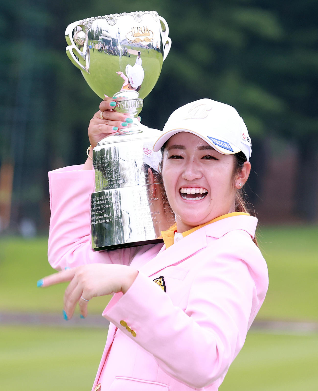 18番、国内メジャー初制覇を決めた稲見は、優勝杯の重たさに「ちょっと休憩」と笑顔で肩に担ぐ（撮影・浅見桂子）
