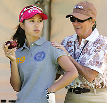 プロアマ戦のスタート前に肩をもまれながらリンゴをかじる上田桃子(共同)