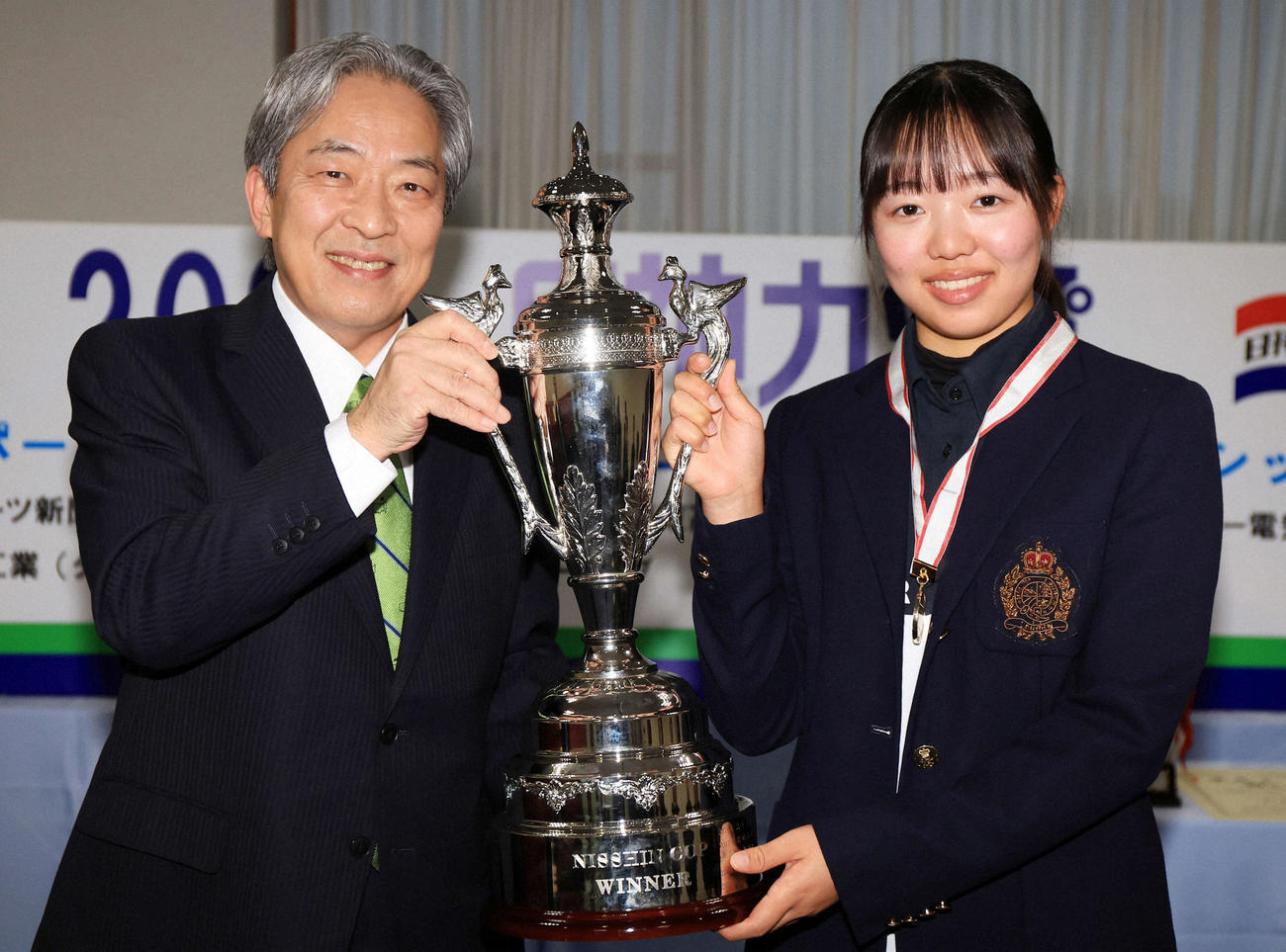 日神不動産の北條滋監査役（左）から日神杯受け取る23年女子高校の部優勝の小宮千鶴